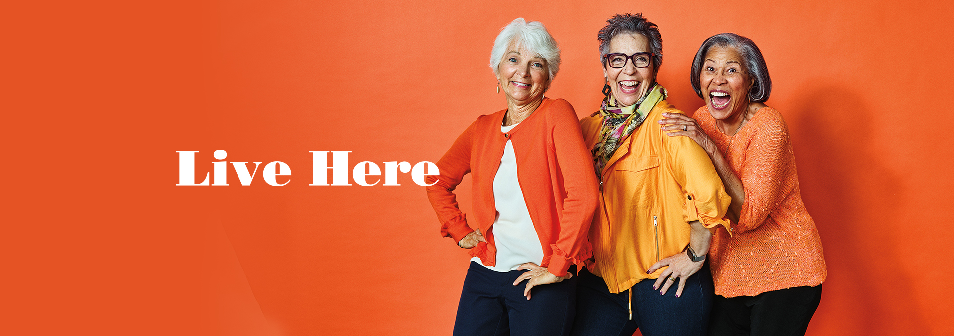 Live Here banner with three women standing in front of an orange background