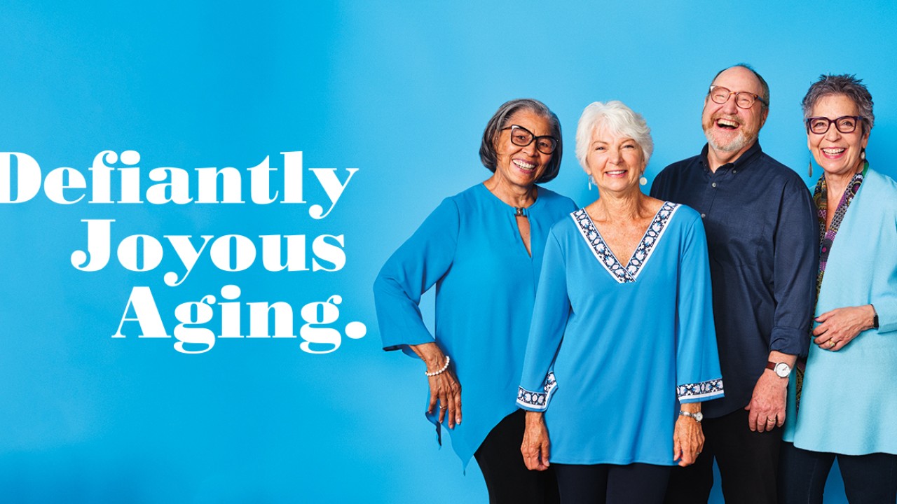 Homepage banner with Defiantly Joyous Aging and 4 people against a blue background