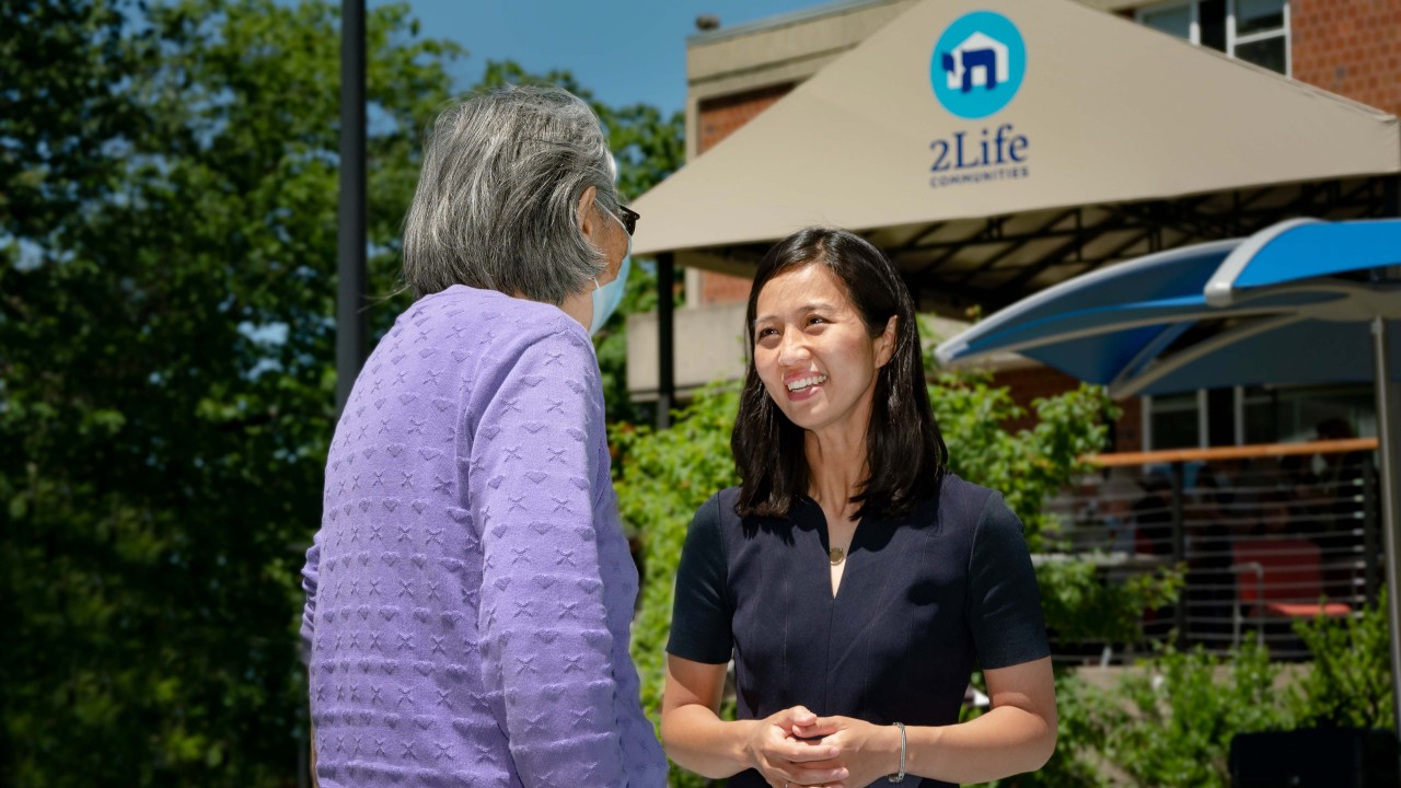 Michelle Wu talking with a 2Life resident after an event