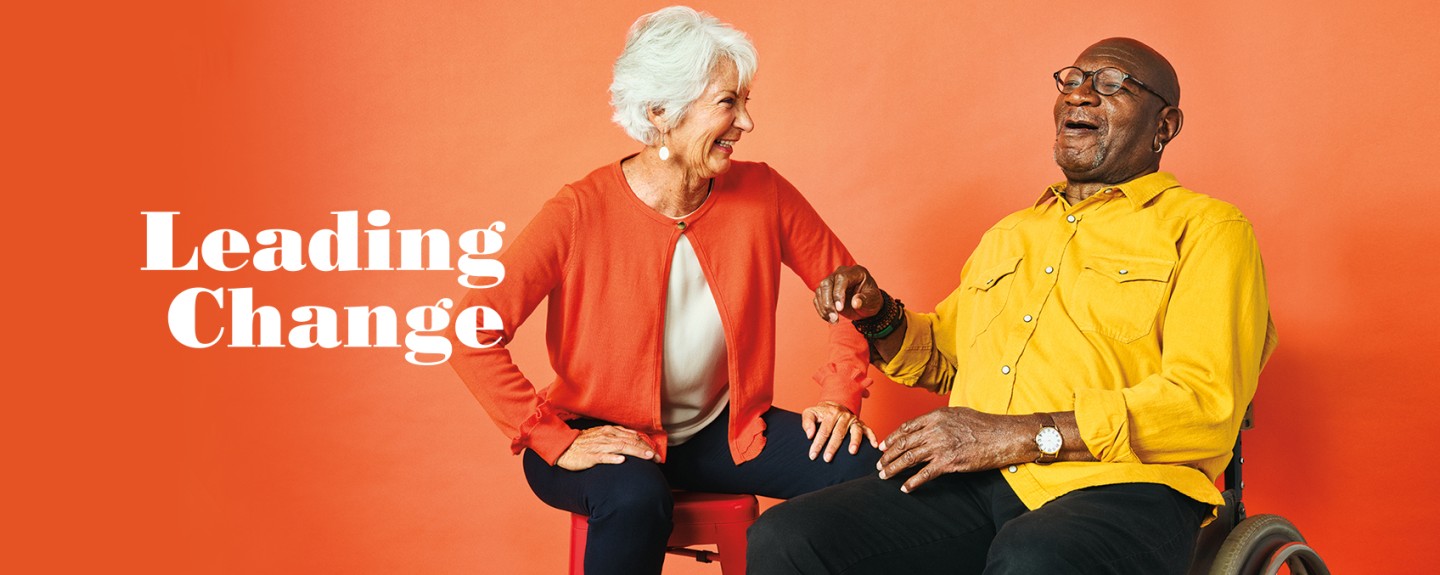 Leading Change banner with two people sitting against an orange background