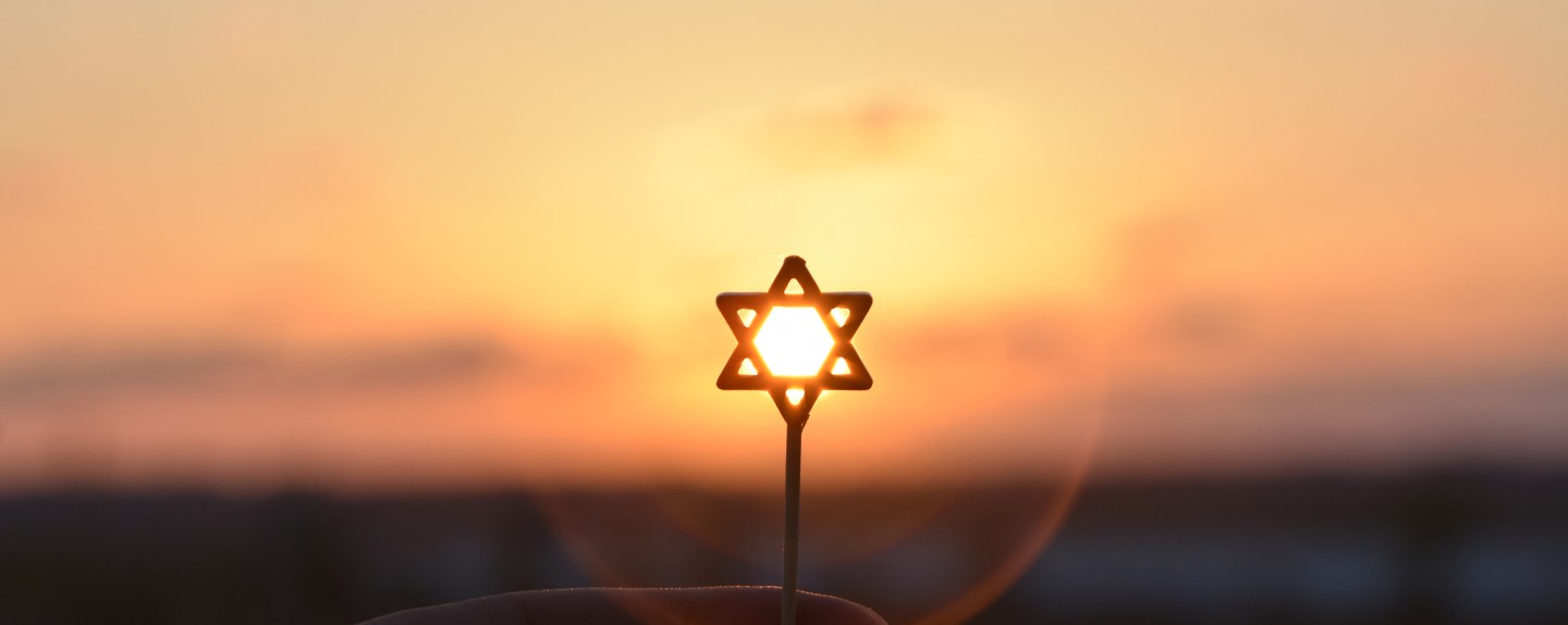 A Star of David silhouetted against a sunset