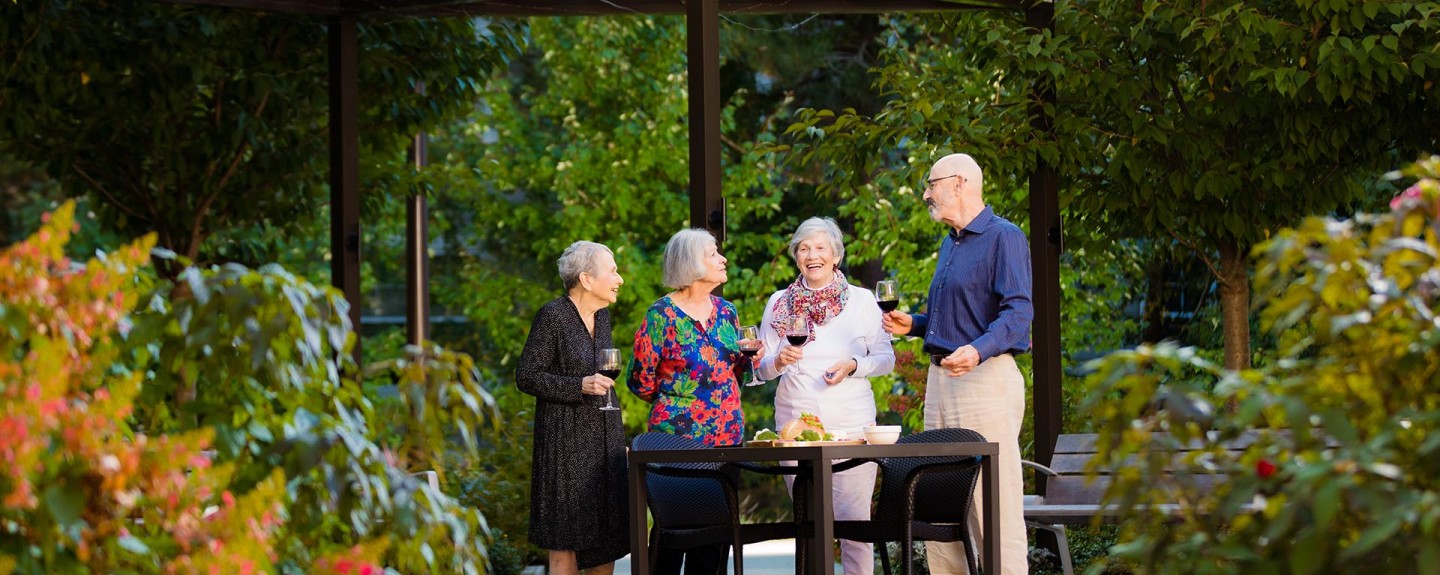 Four people standing outside on a patio