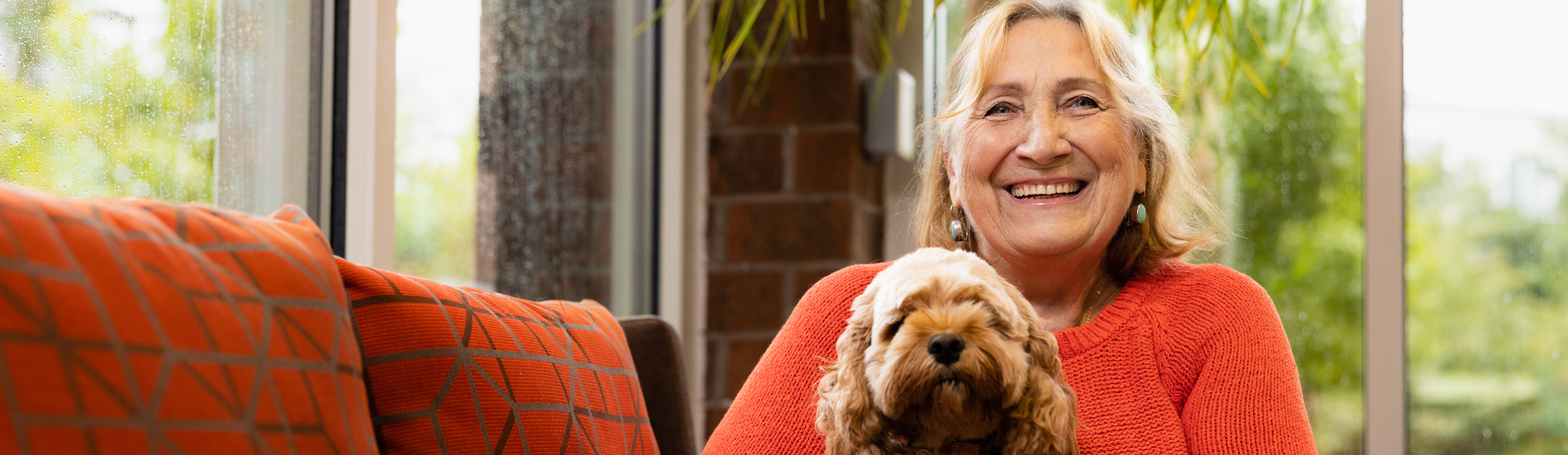 Photo of a smiling resident and dog inside a 2Life community