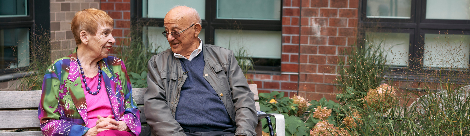 Two residents sitting outside of the Golda Meir House in Newton, MA