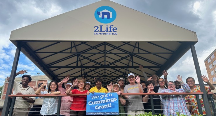 2Life staff and residents posing with a Cummings Grant poster