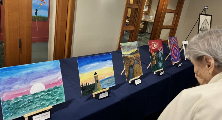 A woman looking at art work on a blue table