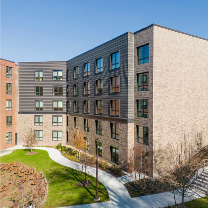 Modern senior living apartment building with landscaped courtyard.
