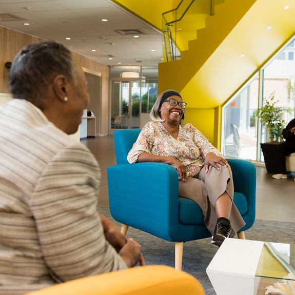 Two women sitting in a bright lobby