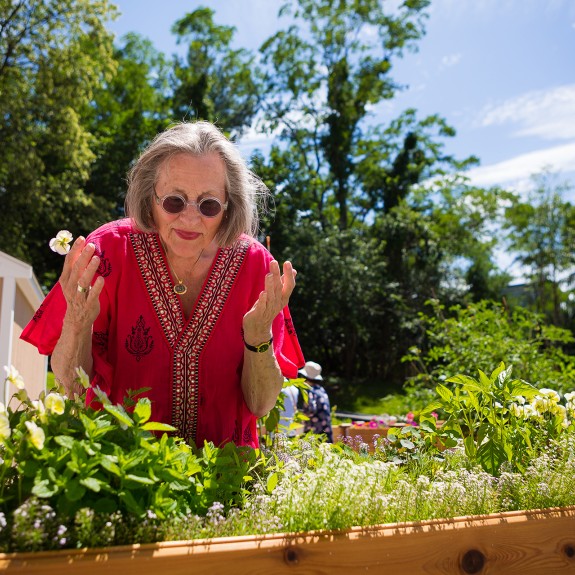 A woman in a red shirt tending to a boxed garden