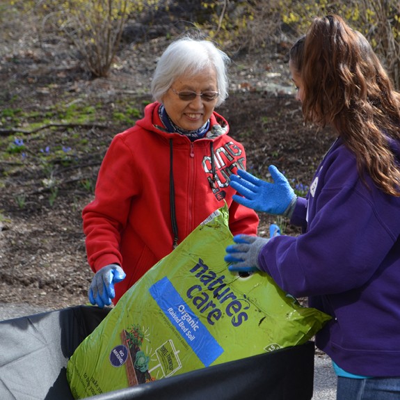 Two women  with a bag of fertilizer