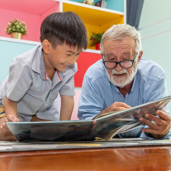 A man reading a book with a child