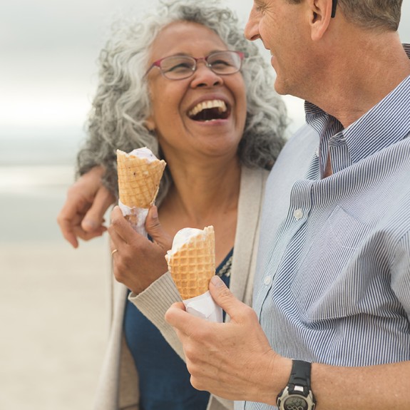 Two people laughing and holding ice cream cones