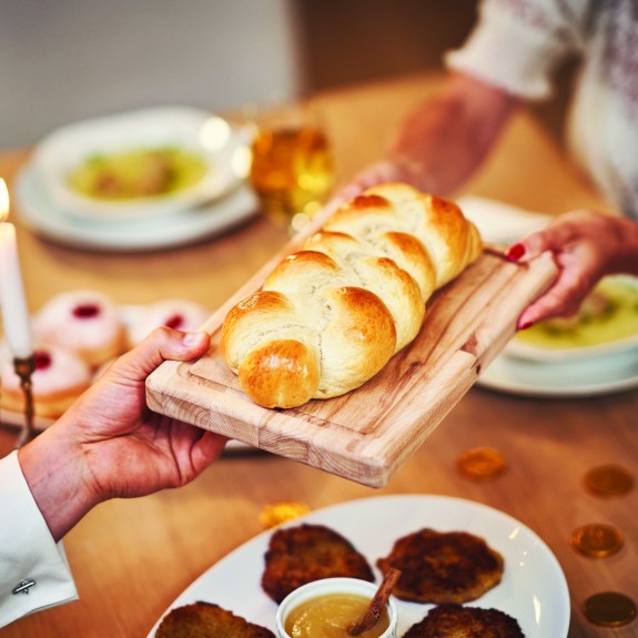 Challah bread being passed over a table