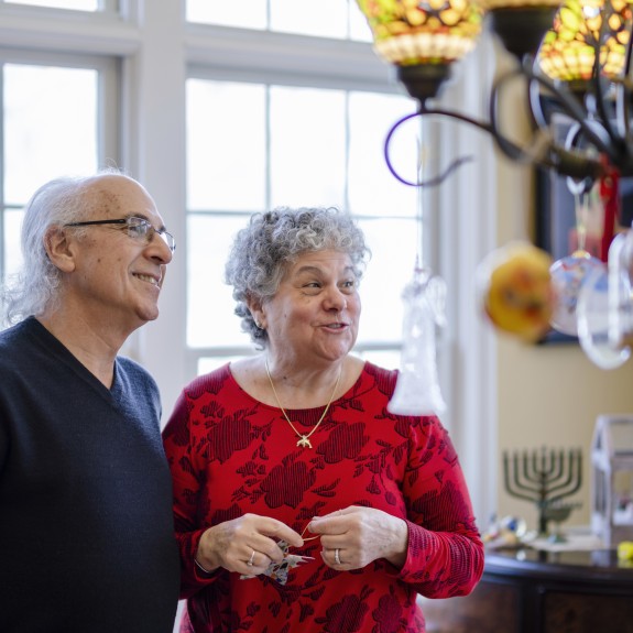 Two people standing in a sunny kitchen