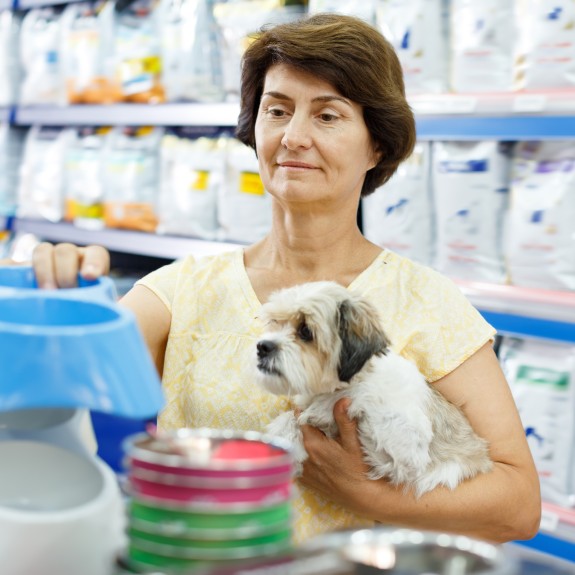 A woman shopping with her dog in a store