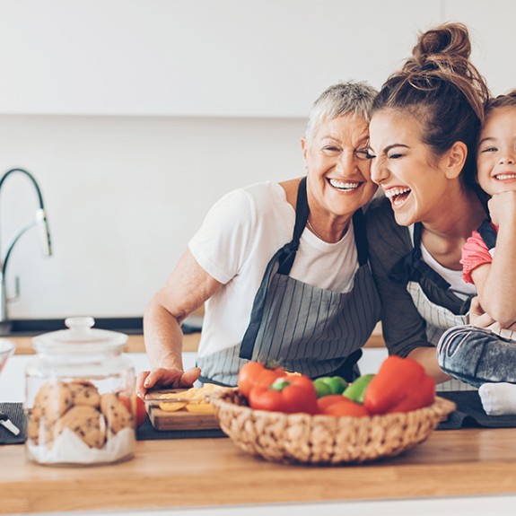 Three people hugging in a kitchen