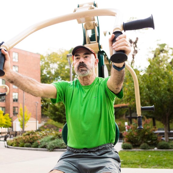 A person using an overhead pull down exercise machine