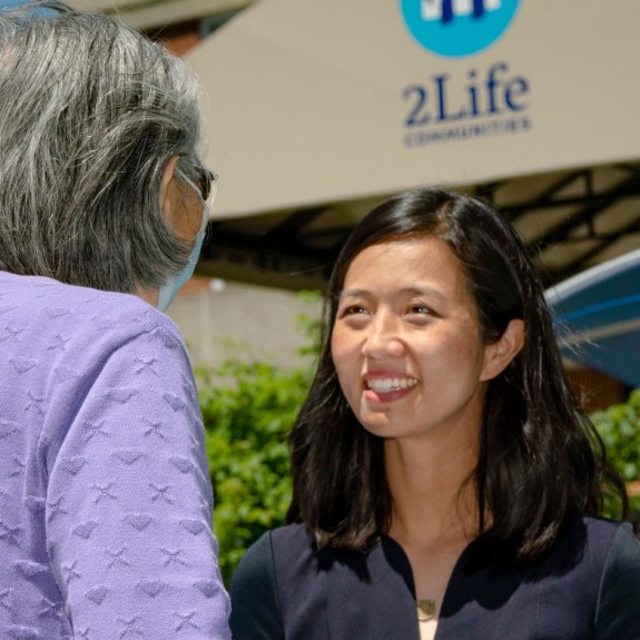 An older Asian woman talking outside with a younger Asian woman
