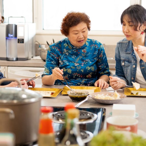 3 Asian people eating together at a table