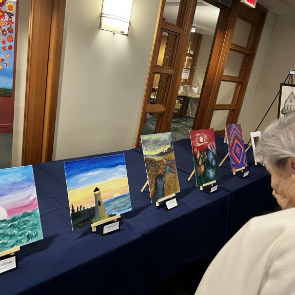 A woman looking at art work on a blue table