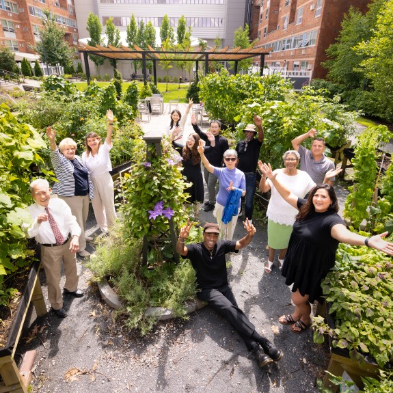 A group of 2Life staff and residents outside in the courtyard 