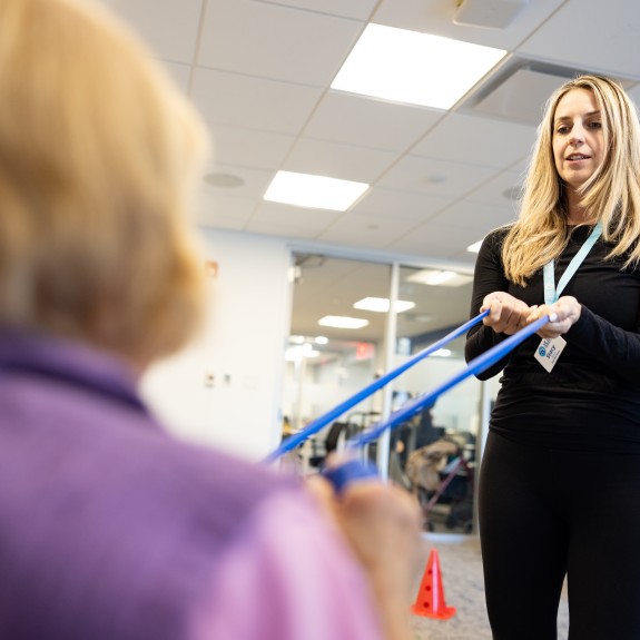 Resident and staff member using exercise equipment