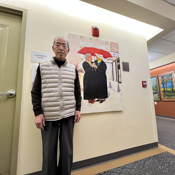 Yon Xin Zhao next to art inside a 2Life campus building