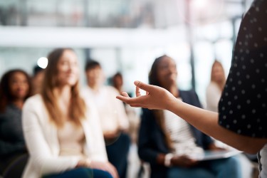 A group of people sitting in front of a presenter