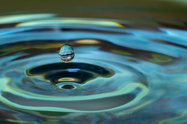 A drop of liquid above a rippling pool of liquid