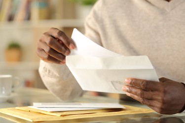 hands removing paper from an envelope