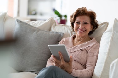 A woman smiling and holding a tablet