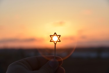 A Star of David silhouetted against a sunset