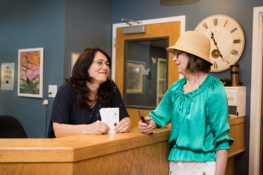 Two women talking at a reception desk