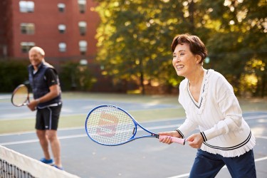Two people playing doubles tennis together