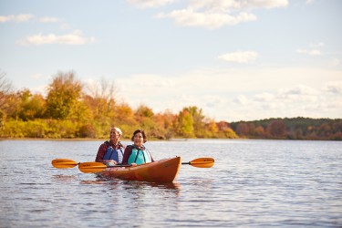 Two people kayaking in the middle of a river