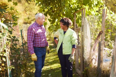 Two people talking in a garden