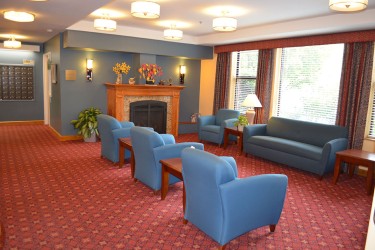 Blue chairs and couches in a room with a fireplace
