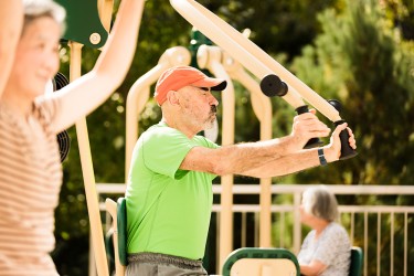 A person pushes a bar of an exercise machine during a workout class
