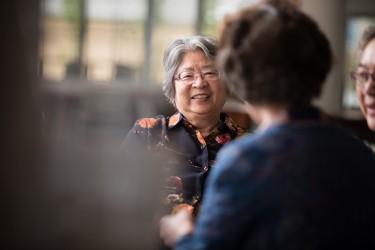 An Asian woman sitting with others