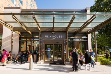 The front of Ulin House with several people talking and sitting outside