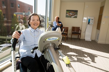 A person exercising on a machine in a sunny room